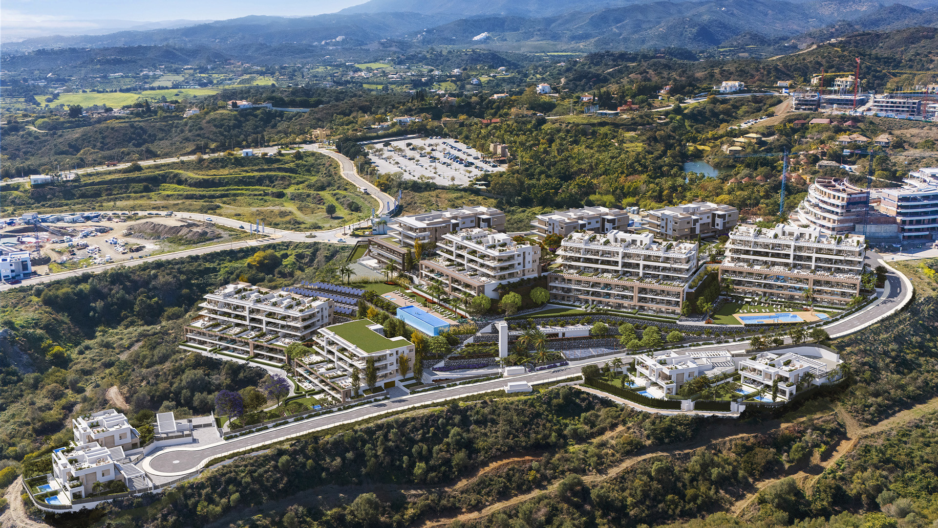 Contemporary hillside development with modern apartments, pools, and scenic mountain views in a lush green landscape.