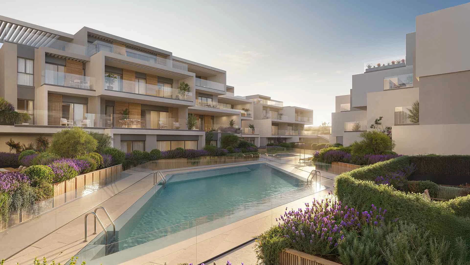 Modern apartment complex with landscaped gardens and a central pool area, featuring contemporary architecture.